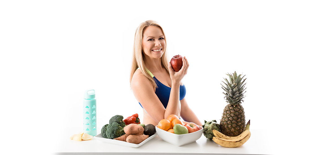 jen-steigert-with-fruits-in-front-eating-apple